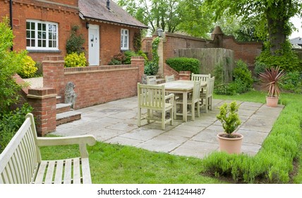 Garden Patio With Stone Slab Paving In A Landscaped Back Garden. Large UK Heritage House Or Country Home