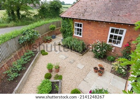 Garden patio UK. Landscaped garden with gravel, raised beds and York stone stepping stones and patio.