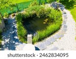 Garden pond. Relaxation zone with fish farming in an organic garden from above. Sustainable development in gardening and aquaculture.