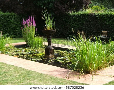 A garden pond with statuary and plants.