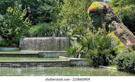 Garden With Pond That Has Waterfalls And A Topiary Sculpture