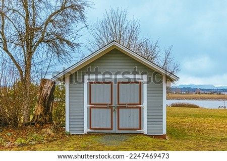 Garden shed front. Gardening tools shed. Garden house, wooden tool-shed. Single-story roofed structure in a back garden used for storage, hobbies, or workshop. Nobody, selective focus