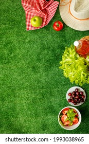 Garden Space With Picnic Basket And Food On Red Cloth. Overhead View