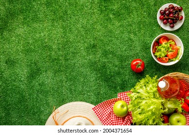 Garden Space With Picnic Basket And Food On Red Cloth. Overhead View