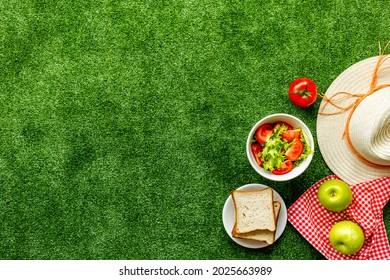 Garden Space With Picnic Basket And Food On Red Cloth. Overhead View