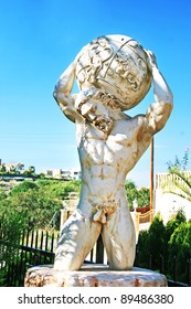 Garden statue of Atlas holding the world on his shoulders .