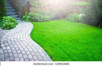 Garden stone path with grass growing up between the stones.Detail of a botanical garden. - Shutterstock ID 1298314483
