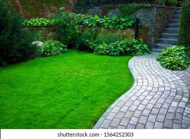 Garden stone path with grass growing up between the stones.Detail of a botanical garden. - Powered by Shutterstock