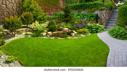 Garden stone path with grass growing up between the stones.Detail of a botanical garden. - Shutterstock ID 1932243626