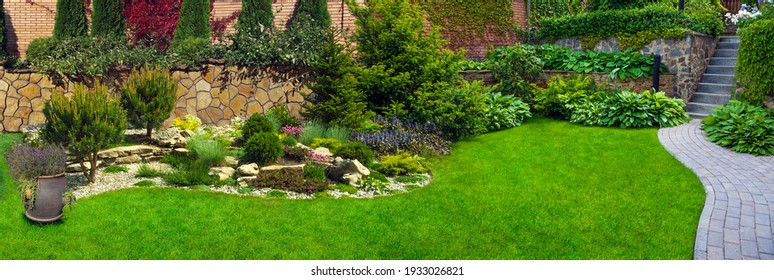 Garden stone path with grass growing up between the stones.Detail of a botanical garden. - Shutterstock ID 1933026821