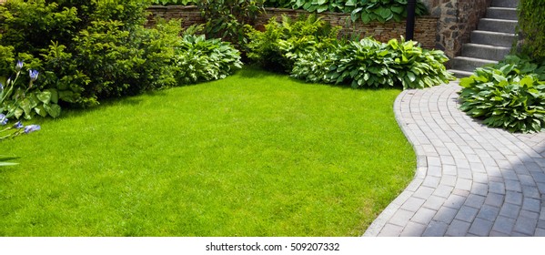 Garden stone path with grass growing up between the stones - Shutterstock ID 509207332