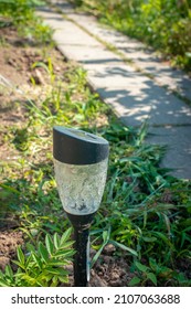 Garden Stone Pathway With Decorative Solar Lights Outdoor. Solar-powered Lamp On Garden Path. Ecological Electrical Energy From Solar Panel In Field