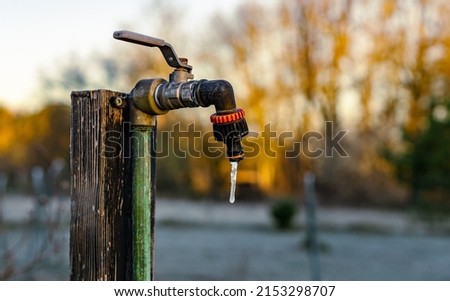 Garden tap with frozen drop of water early cold morning