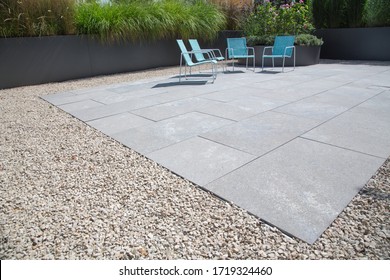 Garden and terrace design with a modern mix of construction material and precious garden decoration objects and various plants