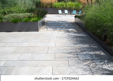Garden and terrace design with a modern mix of construction material and precious garden decoration objects and various plants