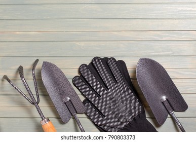 Garden tools on a light wooden background. Flat top view. Space for text