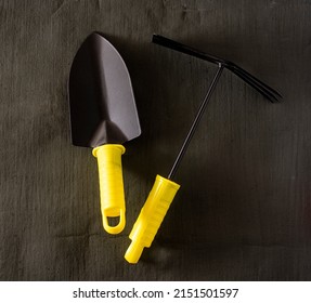 garden tools shovel and rake on a dark tarpaulin. opy space and flatlay.