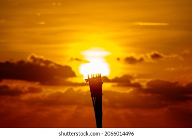 A garden torch candle shot at an angle with the sunrise behind it to make it look like the sun is the candle