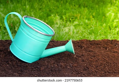 Garden watering can on the soil. Spring and autumn in the garden - Shutterstock ID 2197750653
