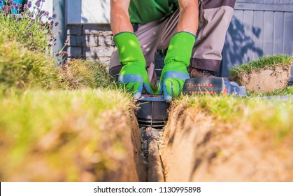 Gardener Building Backyard Garden Watering Systems. Automatic Lawn Sprinklers Installation By Technician.