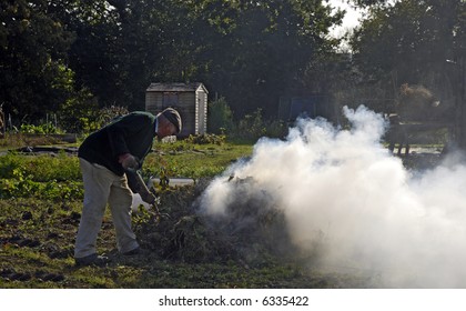 Gardener Burning Garden Waste In Smokey Bonfire