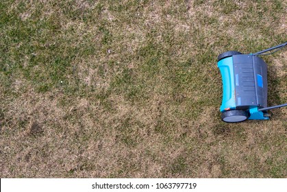 Gardener Operating Soil Aeration Machine On Grass Lawn