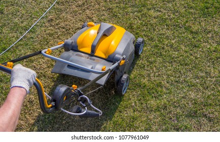 Gardener Operating Soil Aeration Machine On Grass Lawn