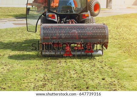 Gardener Operating Soil Aeration Machine on Grass Lawn