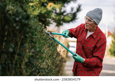 Gardener pruning tree with pruning shears