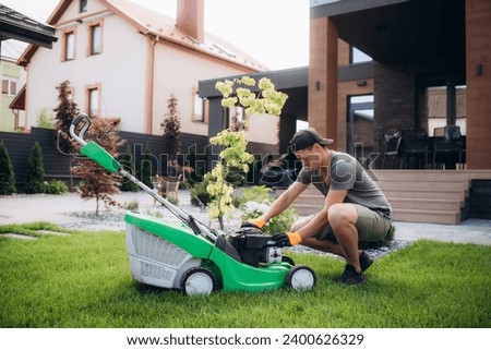 The gardener repairs the lawnmower. Garden maintenance. High quality photo