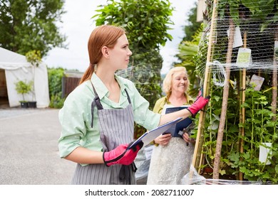 Gardener Team With Checklist When Checking Flower Delivery In Garden Center