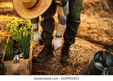 A gardener ties his shoelaces next to a potted plant. - Powered by Shutterstock