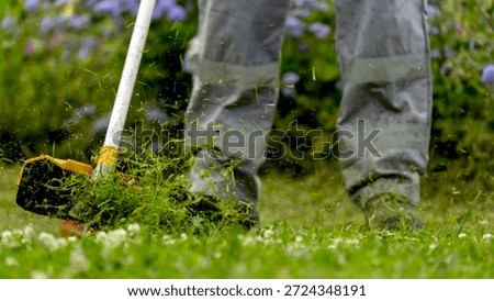 Gardener with trimmer in garden plot