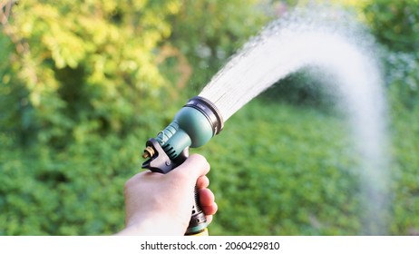 Gardener Watering The Garden With Hose Nozzle