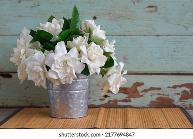 Gardenia Bouquet In The Vase That Put On Bamboo Matt Against Wooden Background.