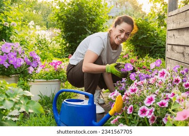 Gardening and agriculture concept. Young woman farm worker gardening flowers in garden. Gardener planting flowers for bouquet. Summer gardening work. Girl gardening at home in backyard - Powered by Shutterstock