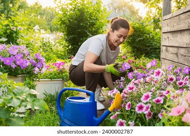 Gardening and agriculture concept. Young woman farm worker gardening flowers in garden. Gardener planting flowers for bouquet. Summer gardening work. Girl gardening at home in backyard - Powered by Shutterstock