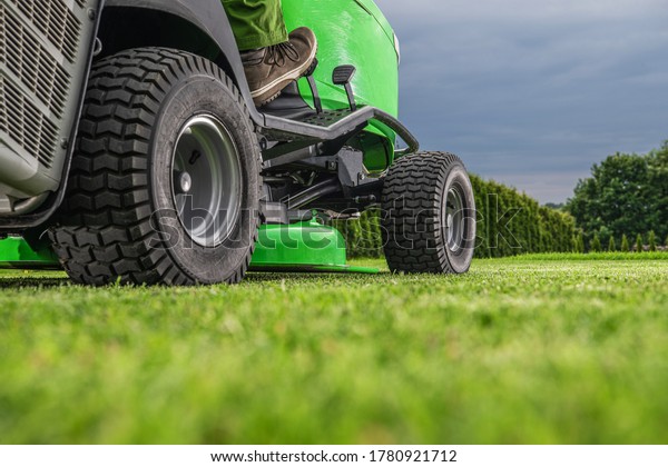 Gardening and Landscaping\
Theme. Outdoor Power Equipment Riding Lawn Mower Tractor Job. Grass\
Mowing Work.
