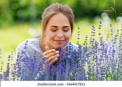 Gardening And People Concept - Happy Young Woman Smelling Lavender Flowers At Summer Garden