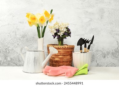 Gardening tools, hyacinth flowers and daffodils, watering can on concrete background. Concept of spring gardening work. Floral arrangement for banner. Mockup for design with place for display.  - Powered by Shutterstock