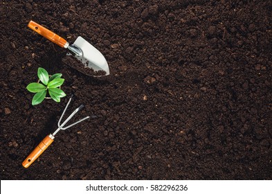 Gardening tools on fertile soil texture background seen from above, top view. Gardening or planting concept. Working in the spring garden. - Shutterstock ID 582296236