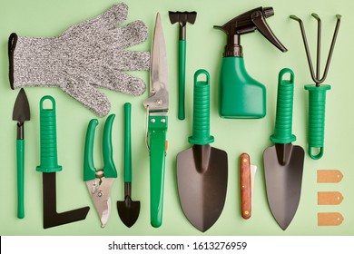 Gardening tools on green background flat lay top view 