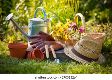 Gardening Tools And A Straw Hat On The Grass In The Garden