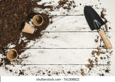 Gardening Tools Top View On White Wooden Planks Background With Copy Space Around Products. Border With Place For Text. Gardening Or Planting Concept Seen From Above. Working In A Clean Indoor Garden.