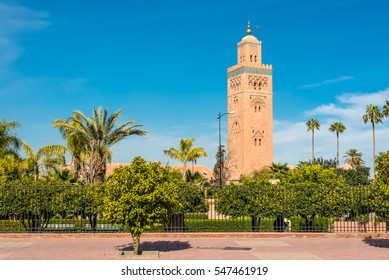 Gardens Flank The Koutoubia Mosque (Kutubiyya Mosque) - The Largest Mosque In Marrakesh, Morocco. The Minaret Tower Includes A Secondary Tower, A Dome, A Spire Of Four Orbs, And A Flag Pole.