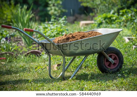 Garden-wheelbarrow filled with soil on a farm