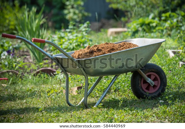 Garden-wheelbarrow filled with\
soil on a\
farm