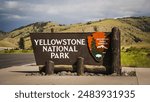 Gardiner, Montana USA - June 26th, 2024: Yellowstone National Park South Entrance Sign in front of the Roosevelt Arch at the north entrance to Yellowstone National Park.