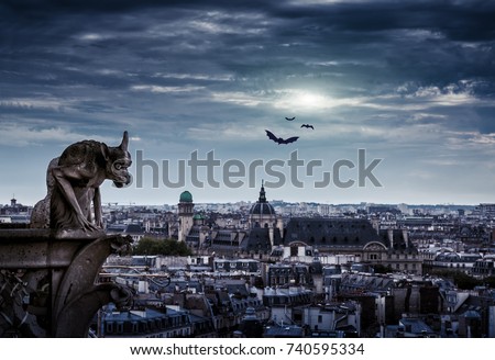 Gargoyle of Notre Dame de Paris Cathedral overlooking city at Gothic night, France. Dark skyline on Halloween. Fantasy mystic view of haunted Paris at dusk. Gloomy panorama of old town in twilight.