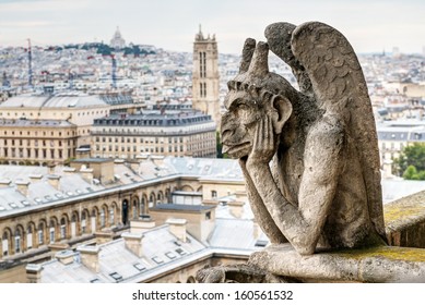 Gargoyle on Notre Dame de Paris cathedral overlooking Paris, France. Notre Dame is architecture landmarks of city. View of thinking demon statue, famous tourist attraction close-up. Melancholia theme